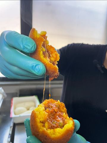 Arancina al ragù aperta, con il ripieno filante