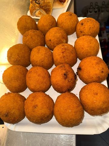 Vassoio pieno di arancine siciliane dorate