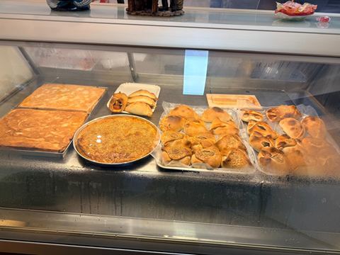 La vetrina calda della rosticceria siciliana con impanate, calzoni e fagottini